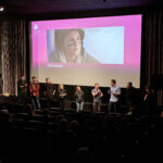 Das Team des Kurzfilms "Tischrebellen" vor der Leinwand. Der Film basiert auf dem Drehbuch "Tischmanieren", mit dem Autor*innen Linn und Luka Peltzer 2019 den Publikumspreis gewannen.